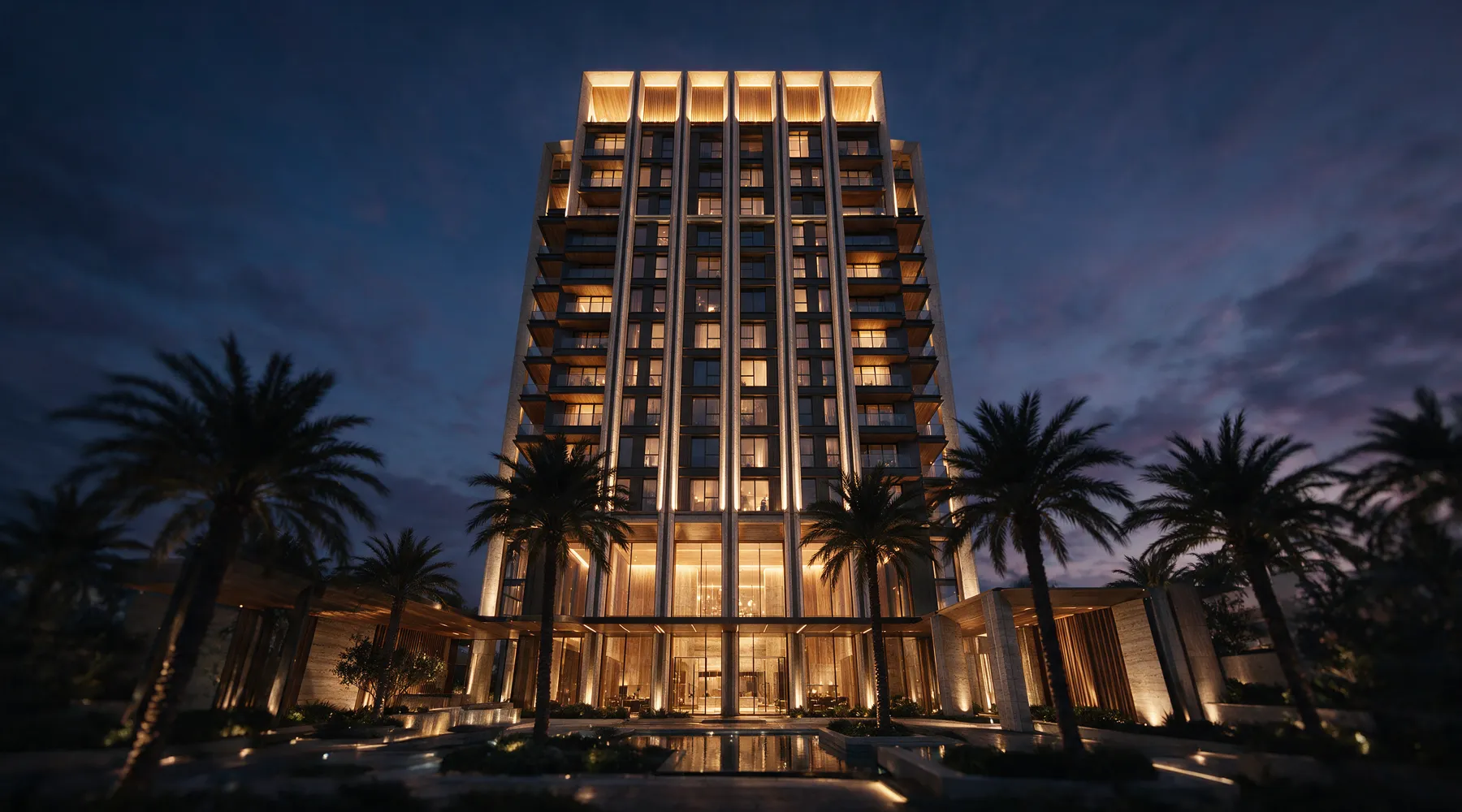 Fachada de torre residencial de alto padrão iluminada ao anoitecer.